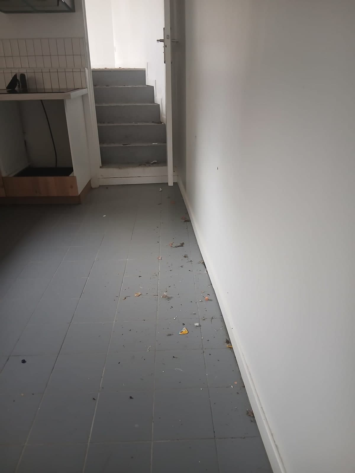 Carrelage de la cuisine jonché de débris de chantier avant nettoyage